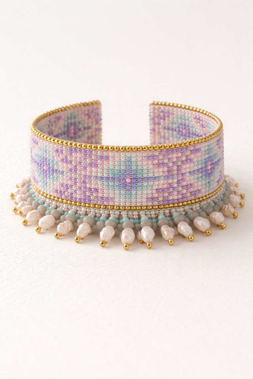 Woven bead cuff bracelet — flat lay, pastel lavender and teal diamond pattern with seed pearl drops