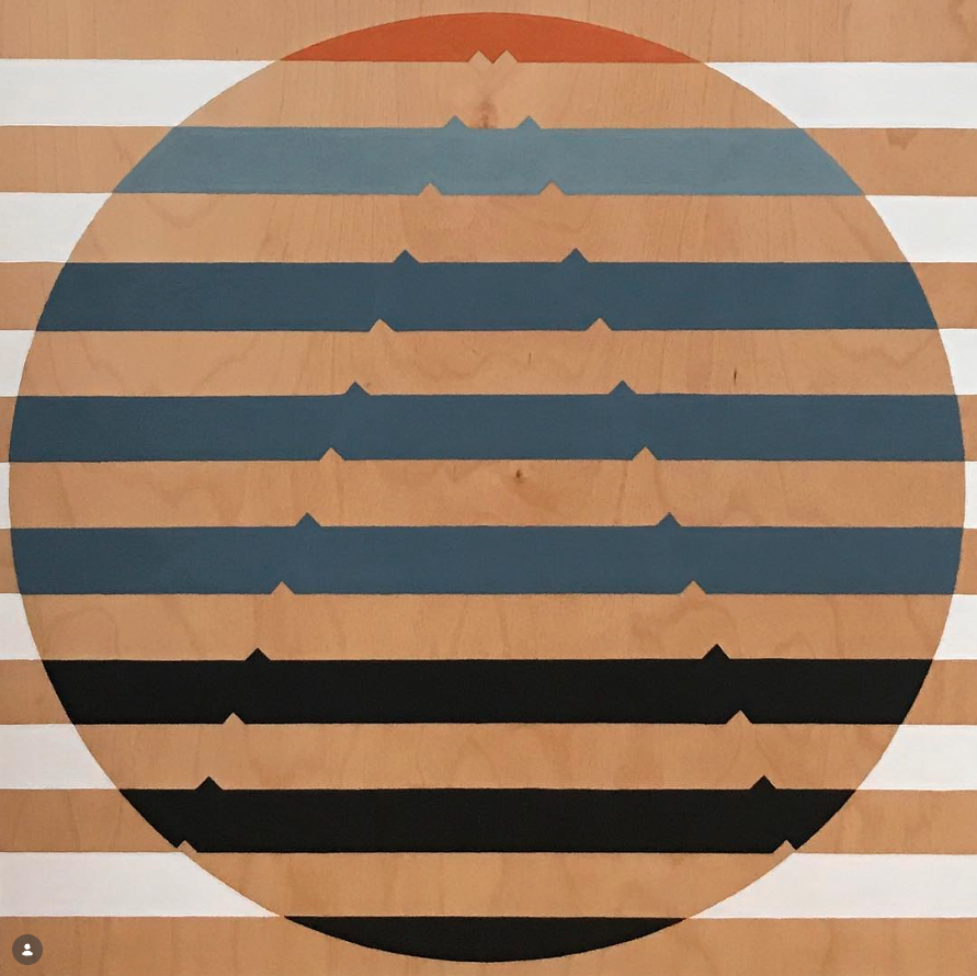 Geometric circle painting on wood panel — concentric horizontal stripes in terracotta, slate blue, and black