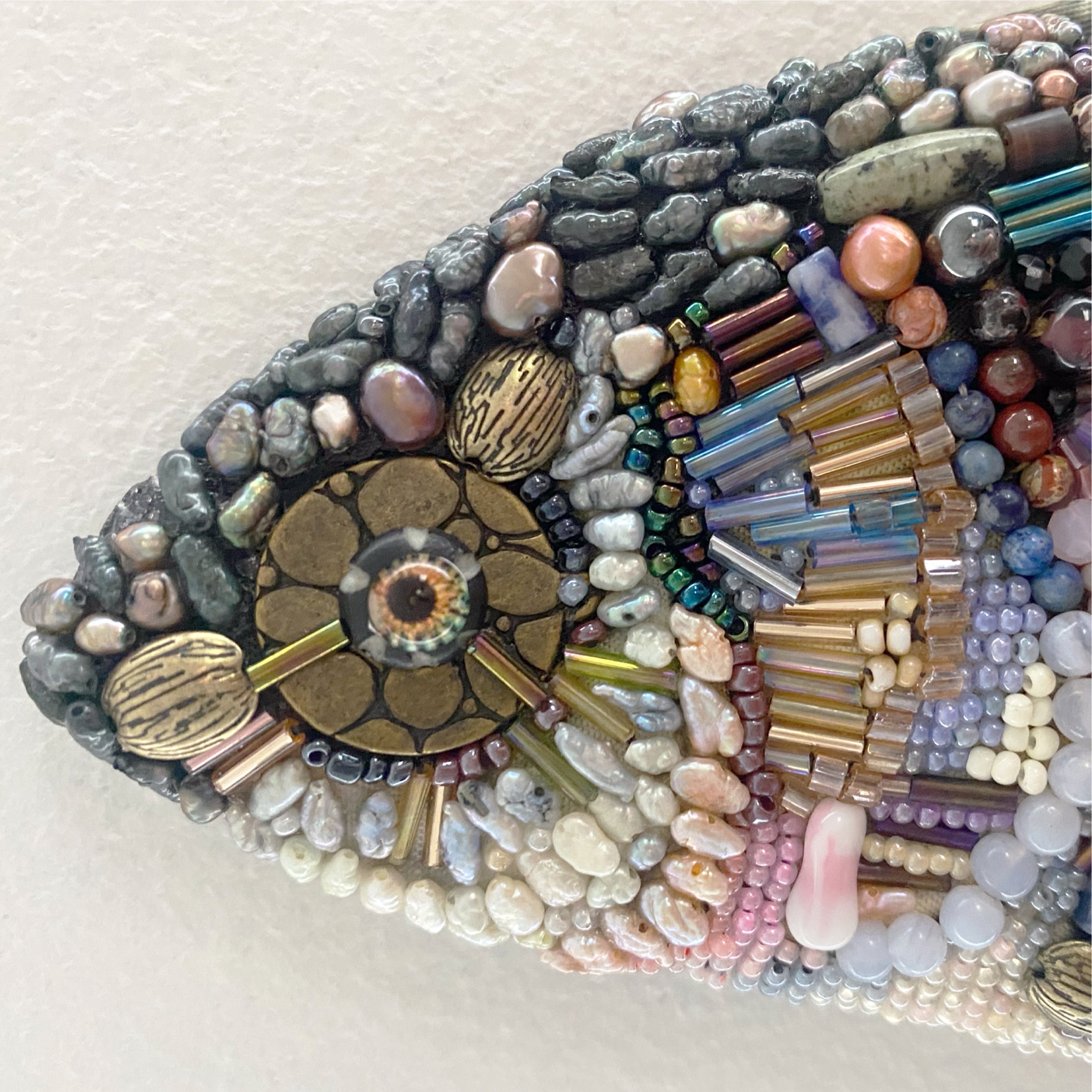 Beaded fish sculpture — close-up detail of the head, gemstone eye, and intricate mixed-bead scales