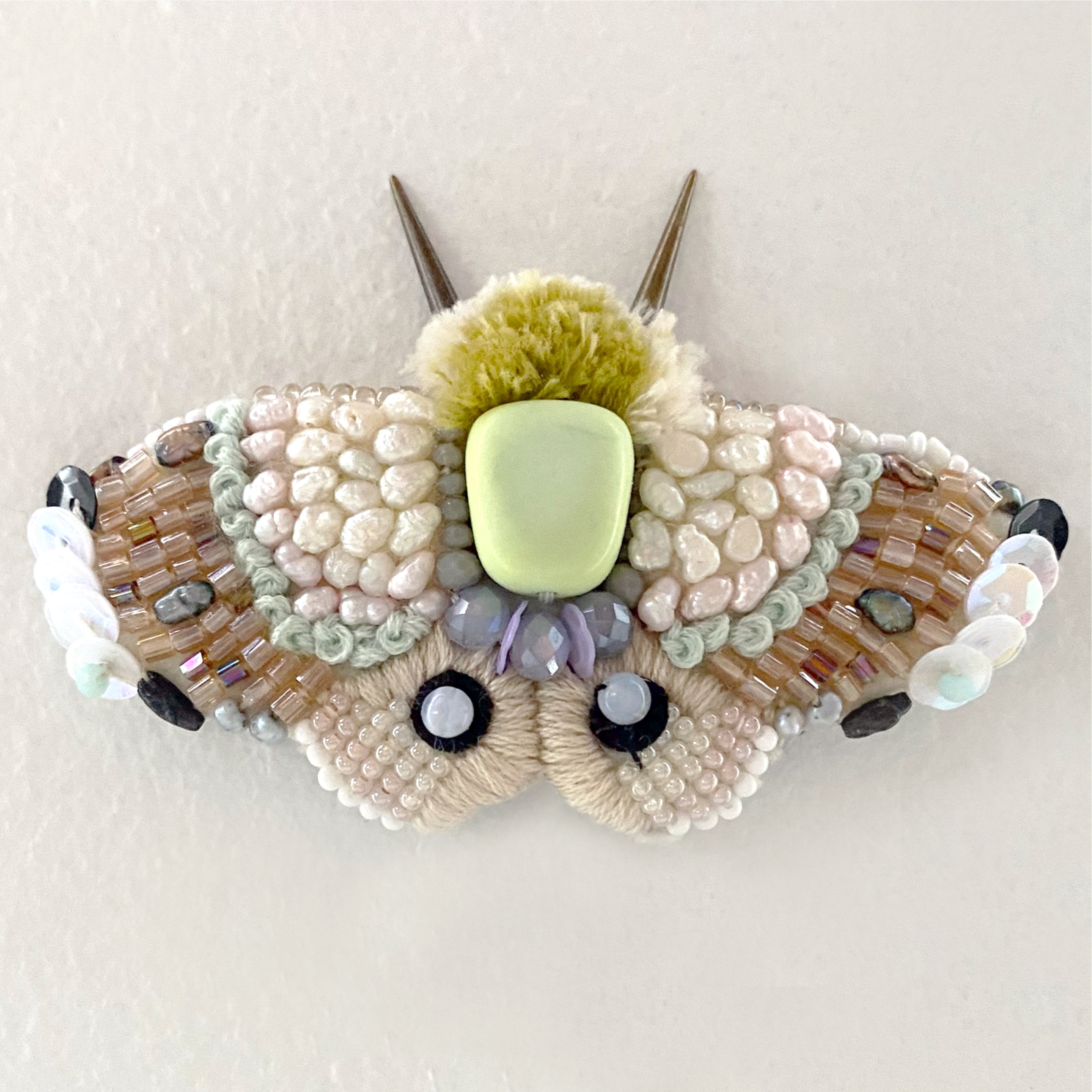 Beaded moth sculpture — full top-down view, pale pink and cream seed beads with pom-pom body and antennae