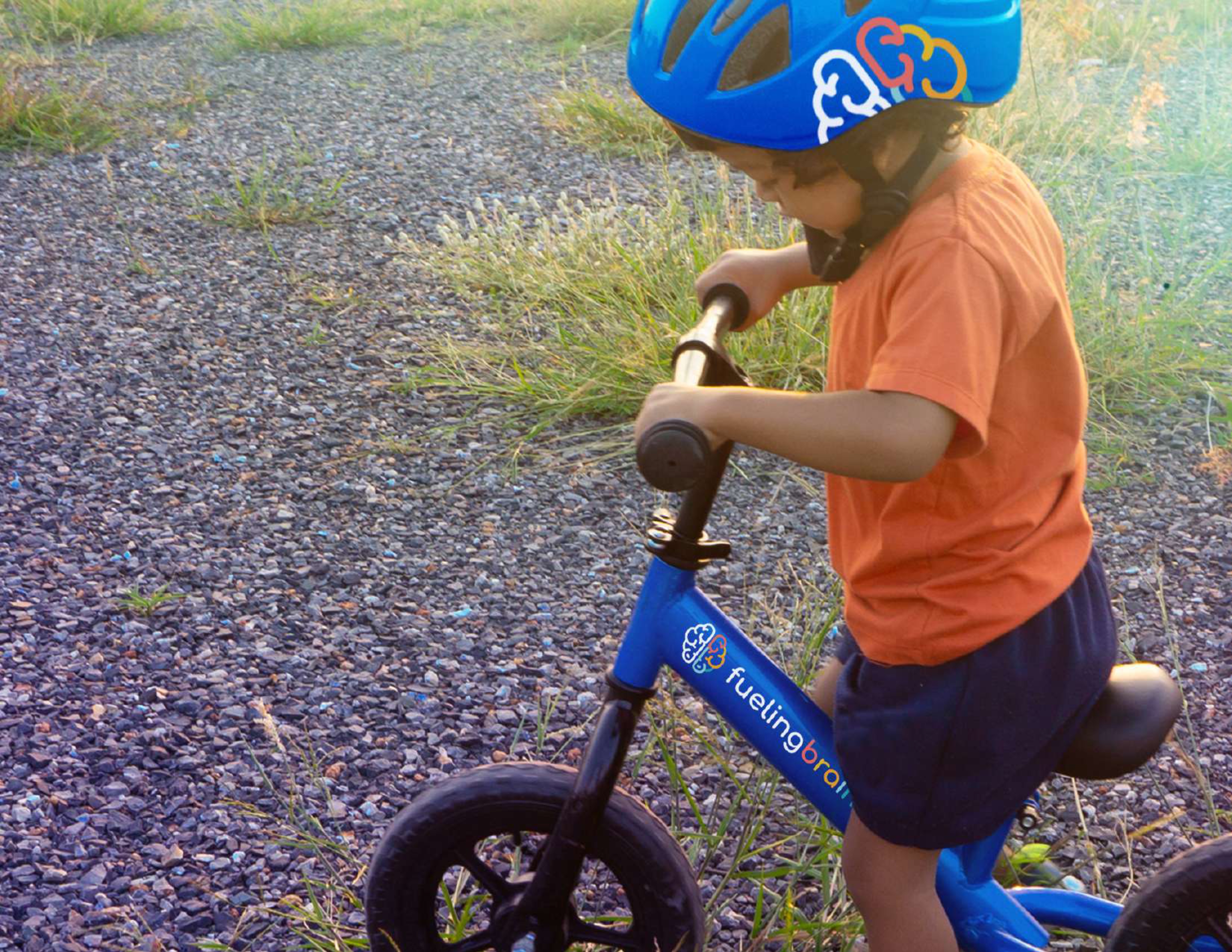 Child riding a Fueling Brains branded balance bike