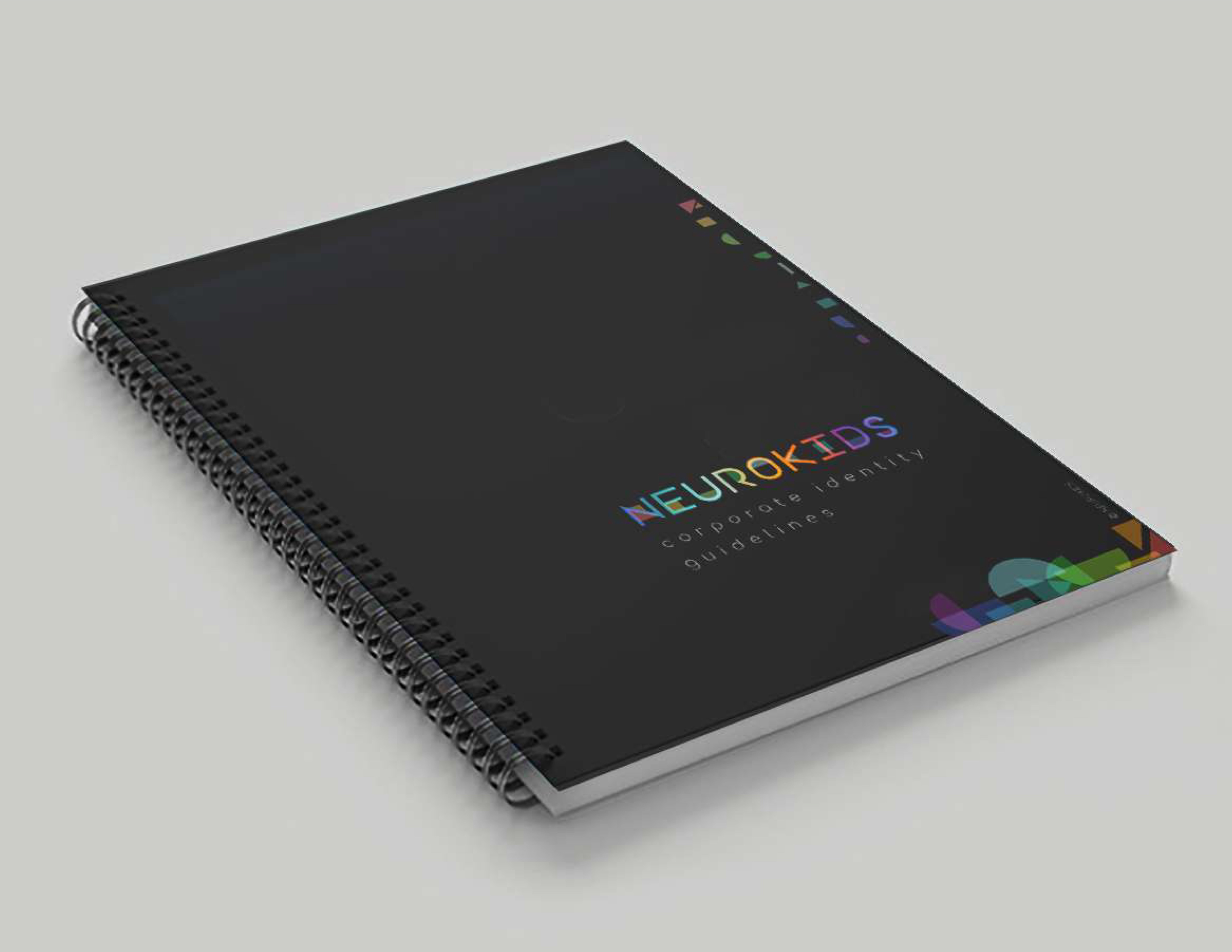 Neurokids 2023 corporate identity guidelines — spiral-bound book on grey