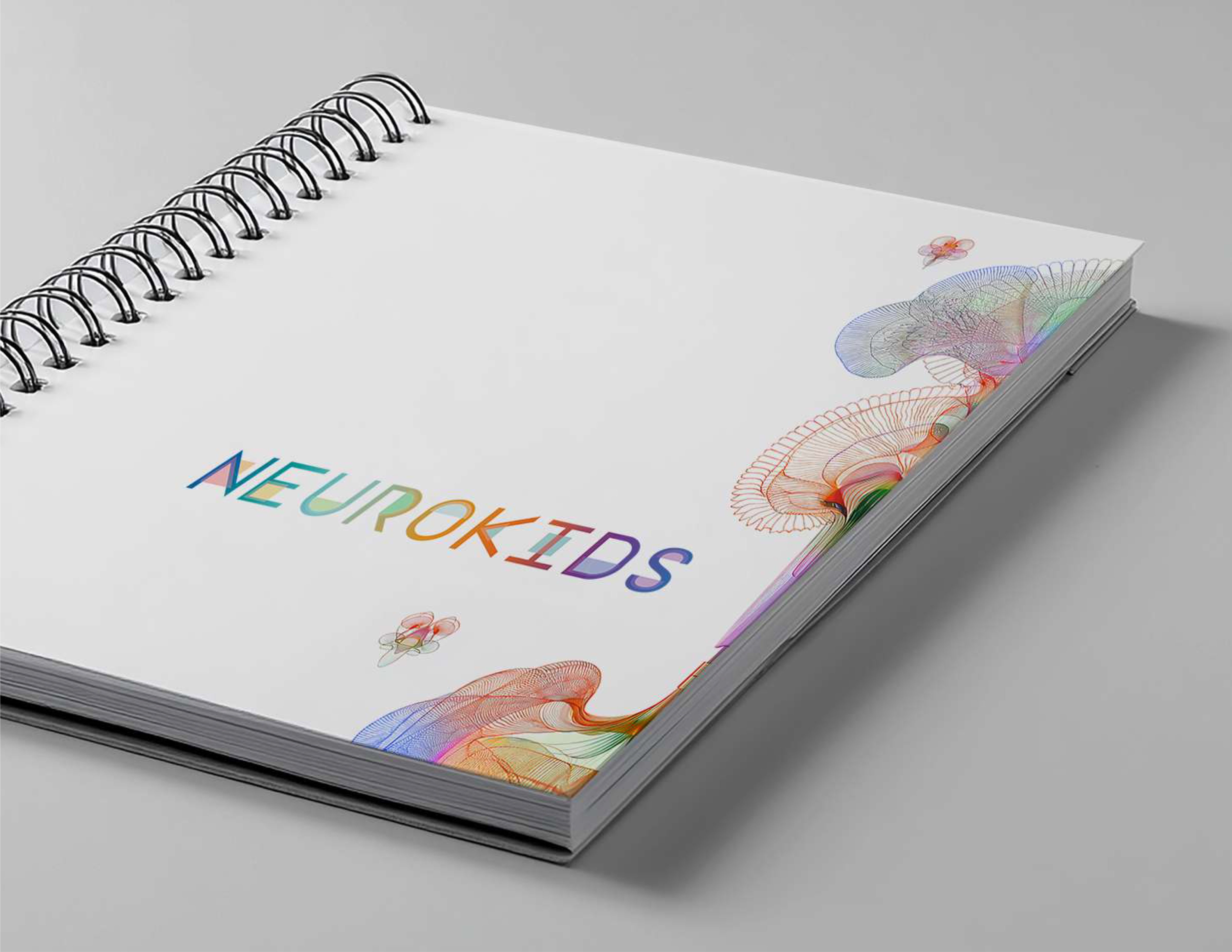 Neurokids 2025 brand guidelines — white spiral-bound book with neural illustration